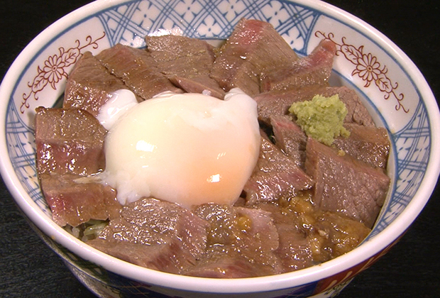 ところせましと肉が収まったどんぶりには、ワサビ、肉味噌、センターに温泉卵が添えられる。