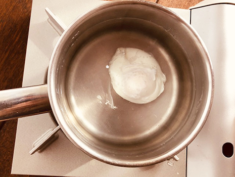 レードル（お玉）でお湯をかき混ぜて、水面にうずが巻く状態にし、玉子を静かに入れて３分待つ
